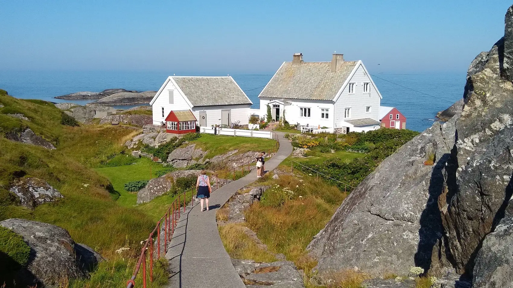 Hvite trehus ytterst ved havet på kysten av Møre og Romsdal